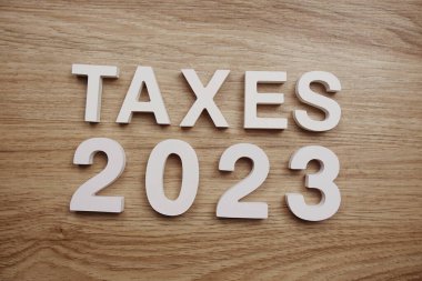 Taxes 2023 alphabet letters on wooden background