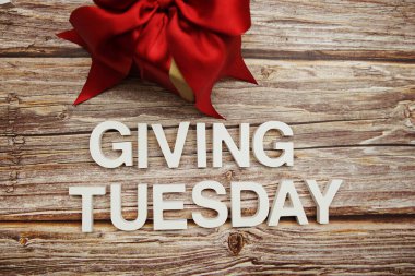 Tahta arka planda Salı alfabesi harfleri ve hediye kutusu vermek.