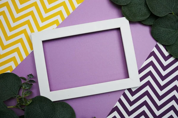 White Frame with Eucalyptus leaves on purple background
