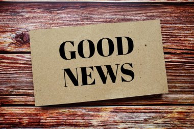 Good news written on paper card top view of wooden background