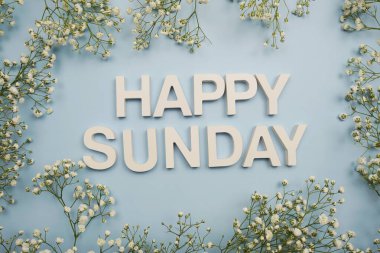 Top View of Happy Sunday alphabet letters on blue background