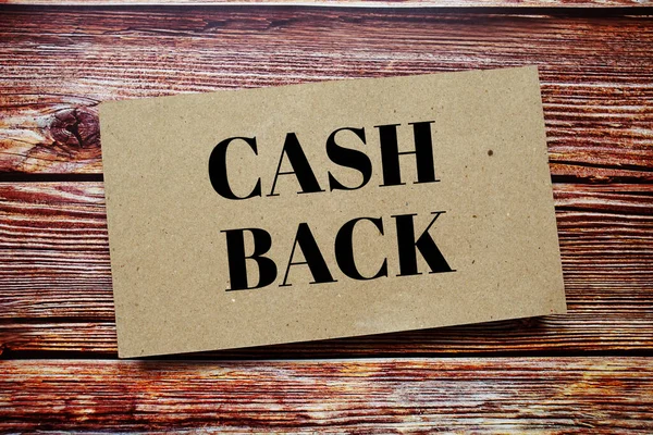 Cash Back written on paper card top view of wooden background
