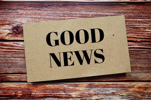 Хорошие новости написаны на бумажной карточке вид сверху на деревянный фон