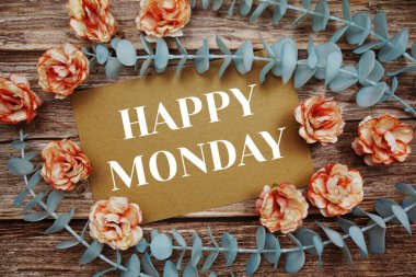 Happy Monday typography text on paper card decorate with flower on wooden background