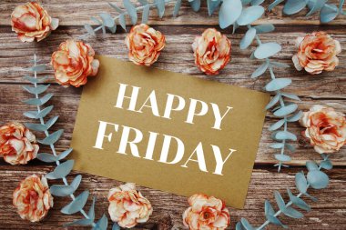 Happy Friday typography text on paper card decorate with flower on wooden background