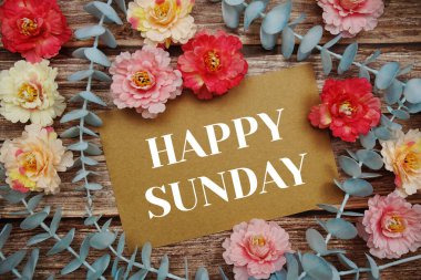 Happy Sunday typography text on paper card decorate with flower on wooden background