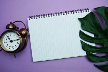 Monstera yapraklarının mor arkaplanda olduğu kopya için boş defter sayfasının kopyası