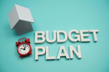 Bütçe Planı alfabesi harfleri ile mavi arkaplan üzerinde ev modeli ve saat