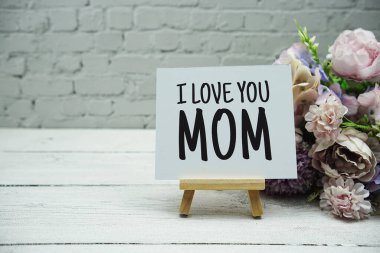 Beyaz tuğla duvara ve ahşap arka plana yazılmış 