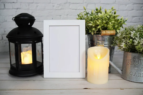 Empty mock up photo frame with LED candle light on white brick wall background