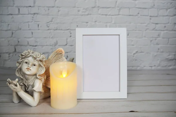 Empty mock up photo frame with LED candle light on white brick wall background