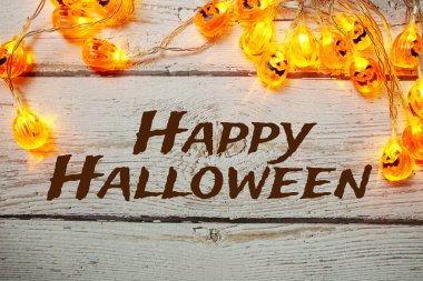 Mutlu Cadılar Bayramı tipografisi metinleri ve Balkabağı Işıkları Ahşap zemin üzerine Cadılar Bayramı Dekorasyonları için LED