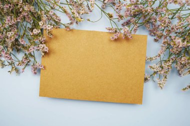 Mavi arkaplanda kopya ve çiçek için boş kağıt kart alanı