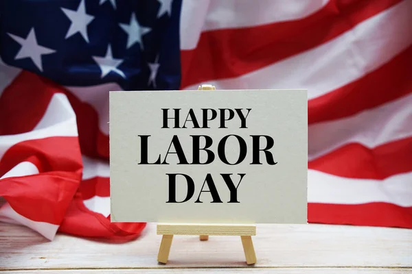 Happy Labor Day text messege  with USA flag on wooden background