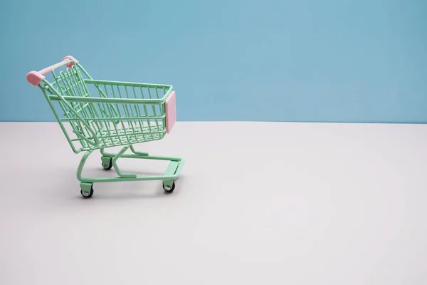 Grüner Einkaufswagen Mit Leerzeichen Auf Blauem Und Rosa Hintergrund — Stockfoto