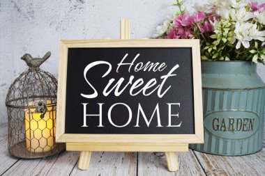 Home Sweet Home mesaj tahtası üzerine yazılmış ahşap arka planda duruyor