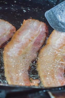 Bir tabakta dilimlenmiş pastırma, yanında yumurta ve bir fincan kahve.