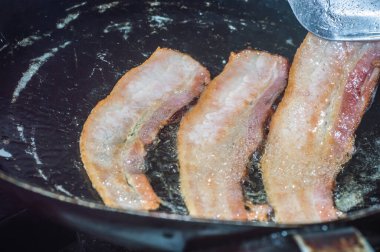 Bir tabakta dilimlenmiş pastırma, yanında yumurta ve bir fincan kahve.