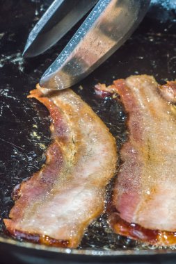 Bir tabakta dilimlenmiş pastırma, yanında yumurta ve bir fincan kahve.