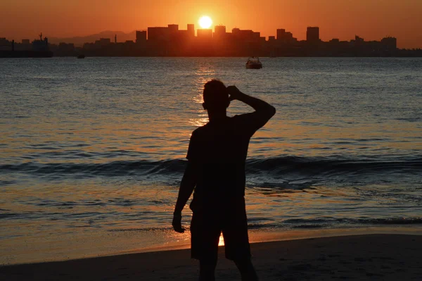 Niteroi, Rio de Janeiro 'da gün batımına hayran olan adam.