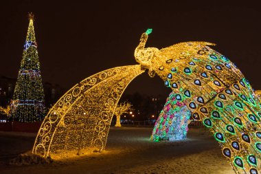 Yeni Yıl ve Noel gecesi aydınlatma kemeri Moskova, Rusya 'da tavus kuşu figürleri ve desenleriyle tasarlandı