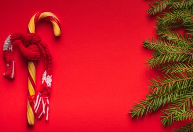 Kırmızı arka planda eşarplı yılbaşı şekeri olan yeni noel ağacı