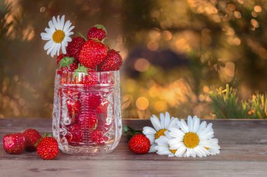 Tahta bir masada çiçekler ve böğürtlenler