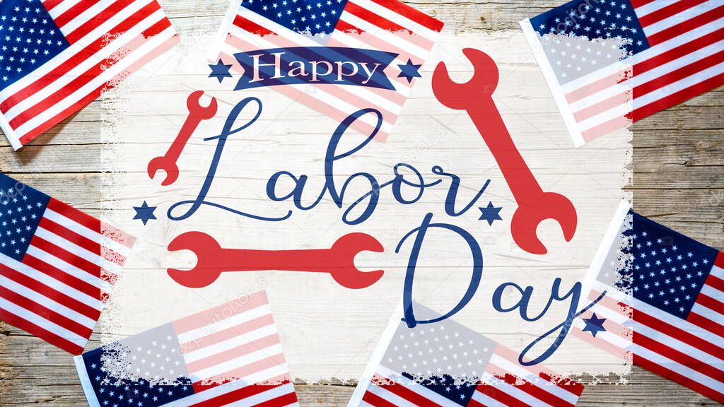 Happy Labor Day background banner greting card template - American flags and lettering with wrench working symbols, isolated on rustic wood texture, wooden table, top view