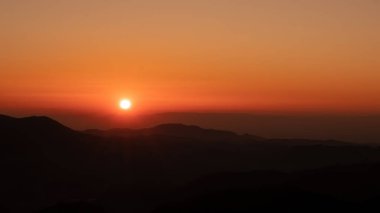 Günbatımından muhteşem bir manzara. Dağlardan silueti ve Kara Orman Almanya 'sında ormanı var.