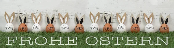 快乐的复活节背景贺卡 许多褐色和白色的复活节彩蛋 有兔子耳朵 复活节兔子在新鲜的绿色草地上 与白色的古董色墙质感隔离 — 图库照片