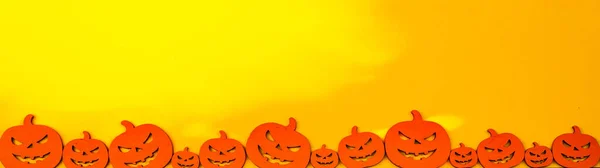 Hallowen ハロウィーン の背景バナーワイドパノラマテンプレート Scary彫刻された明るい漫画木製のオレンジ色のカボチャと黄色のオレンジ色の紙のテクスチャに隔離 — ストック写真