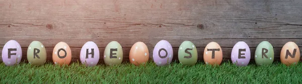 Happy Easter背景横幅全景贺卡 许多彩绘复活节彩蛋在新鲜的绿色草甸和乡村木墙上 — 图库照片