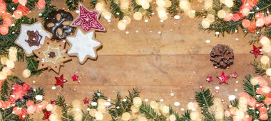 Noel / Noel şablonu şablonu / tatil kartı - Kırsal ahşap masa dokusunda firavun dalları, noel kurabiyeleri, yıldızlar ve bokeh ışıkları üst görünümü