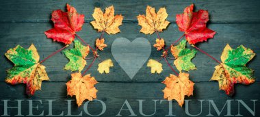 Merhaba sonbahar - Arka plan, pek çok rengarenk rengarenk soyut akçaağaç yapraklarının üst görünümü koyu siyah ahşap masa dokusu, harfler ve kalp ile izole