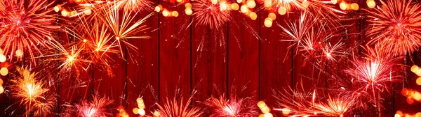 シルベスターパーティー新年花火の背景バナーパノラマ長いです テキストのためのスペースと素朴な赤い木製のテクスチャ上の花火とボケライト — ストック写真