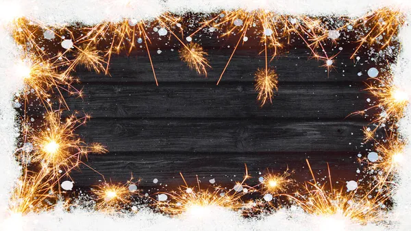 シルベスター 新年のクリスマスや他のお祝いの休日の背景 雪の結晶 輝きやボケライトで作られたフレーム 素朴な黒い木製のテーブルウォールボードの木のテクスチャ トップビュー — ストック写真