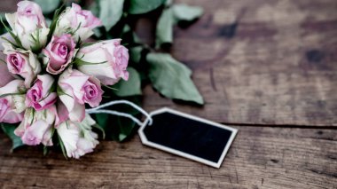 Rustik ahşap masa üzerinde pembe gül buketi