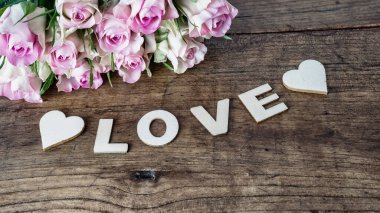 Aşk arkaplanı - Kırsal ahşap masada bir buket pembe gül