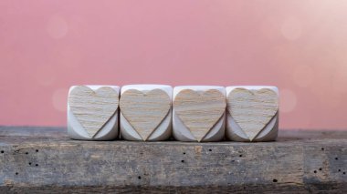 Sevgililer Günü 'nde Aşk Düğününde arka planda tebrik kartı - Kırsal ahşap ahşap masa dokusunda kalp sembolü olan tahta küpler pembe romantik bokeh ışıkları