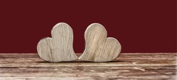 バレンタインデーバレンタイン 結婚式の背景バナーパノラマ 素朴な木製のテーブルの上に2つの木製の心 赤いテクスチャ テキストのためのスペース — ストック写真