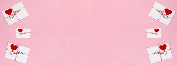 ハッピーバレンタインデーの背景バナーグリーティングカード ピンクの紙のテクスチャに隔離された白いリボンと赤いハートを持つ3つの白い封筒 トップビューフラットレイ — ストック写真