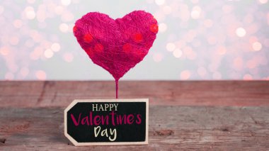 Sevgililer Günü arkaplan tebrik kartı - Kırmızı balon kalp ve kırsal klasik tahta masa dokusu üzerinde romantik bokeh ışıkları olan kara tahta tabela