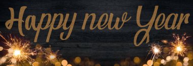 Işıkların çerçevesi bokeh altın fişekleri ve koyu mavi ahşap dokuda izole edilmiş maytap Yeni Yıl 'ın Silvester Yeni Yıl Partisi şenlik arkaplan tebrik kartı