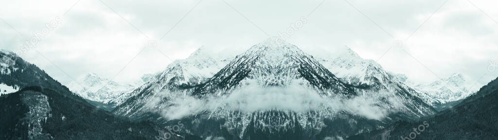 Amazing mystical rising fog forest snow snowy trees landscape snowscape in the mountains winter, Germany Allgu panorama banner - dark mood.