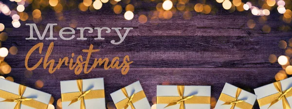 メリークリスマスバックグラウンドホリデーグリーティングカード 素朴な暗い木製の壁のテクスチャに孤立して存在するボケライト フレア ギフトボックスのフレーム — ストック写真