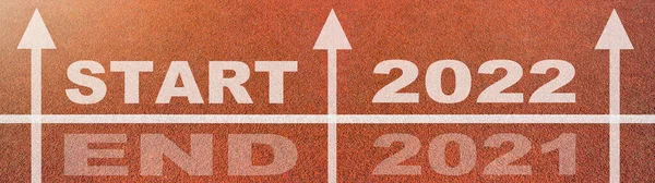 新的一年2022年或开始直接概念背景横幅全景 Word Start 2022 End 2021写在运动场上的橙色跑道上 带有箭头 顶部视图 — 图库照片