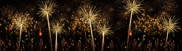 Fireworks pyrotechnics celebration party event festival holiday or New Year background panorama - Golden firework on dark night sky....