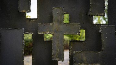 Religious background - Old weathered metal fence with cross shape symbol on cemetery