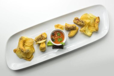 Ahtapot ve patates cipsli tabağın üst görüntüsü