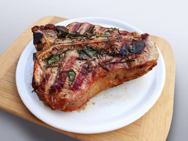 Bütün beyaz yuvarlak plakalı beyaz arka plan üzerinde izole T-bone biftek ızgara